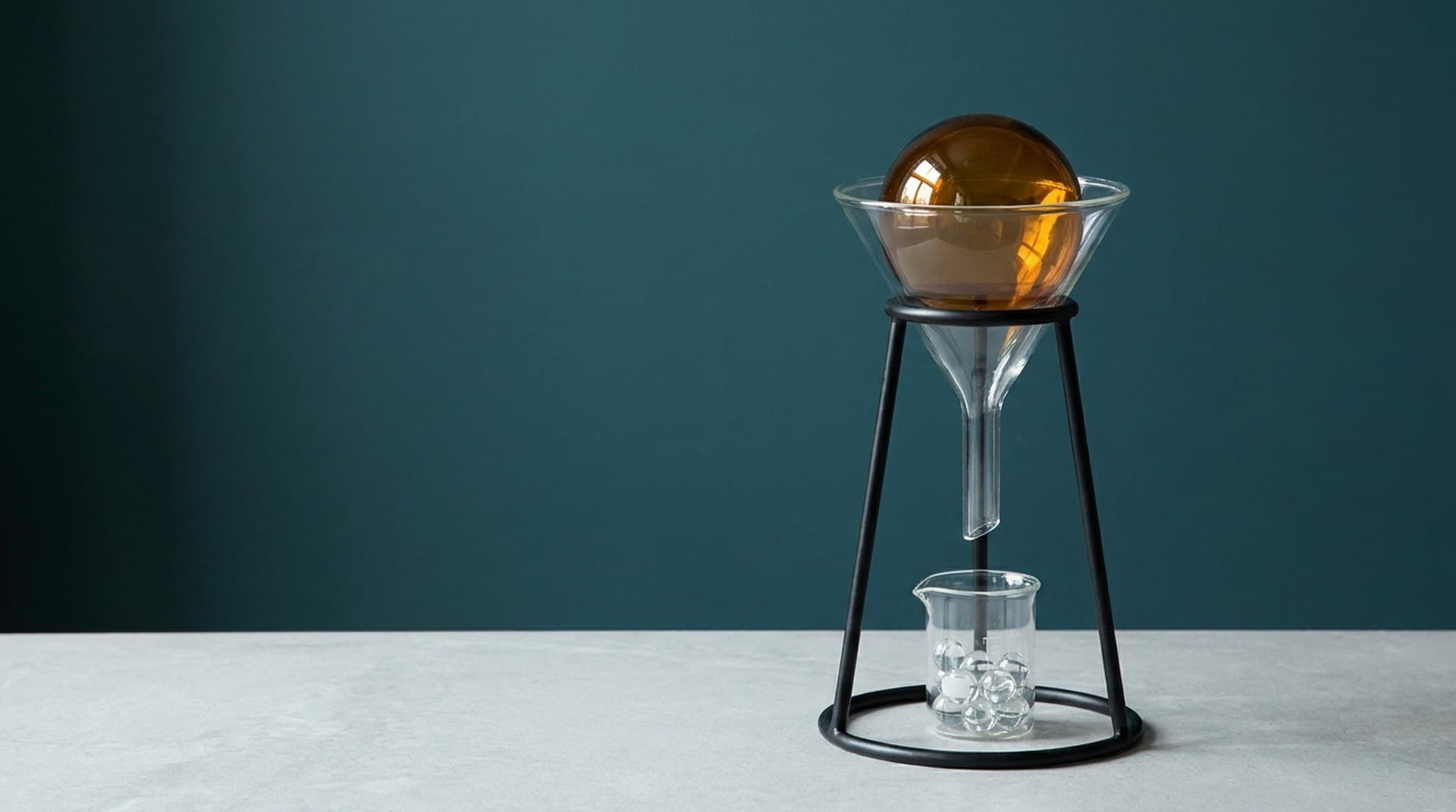 A large amber glass sphere stuck in the mouth of a glass lab funnel while small clear beads have already passed into a beaker below, a metaphor for the Claude API 413 request_too_large size limit